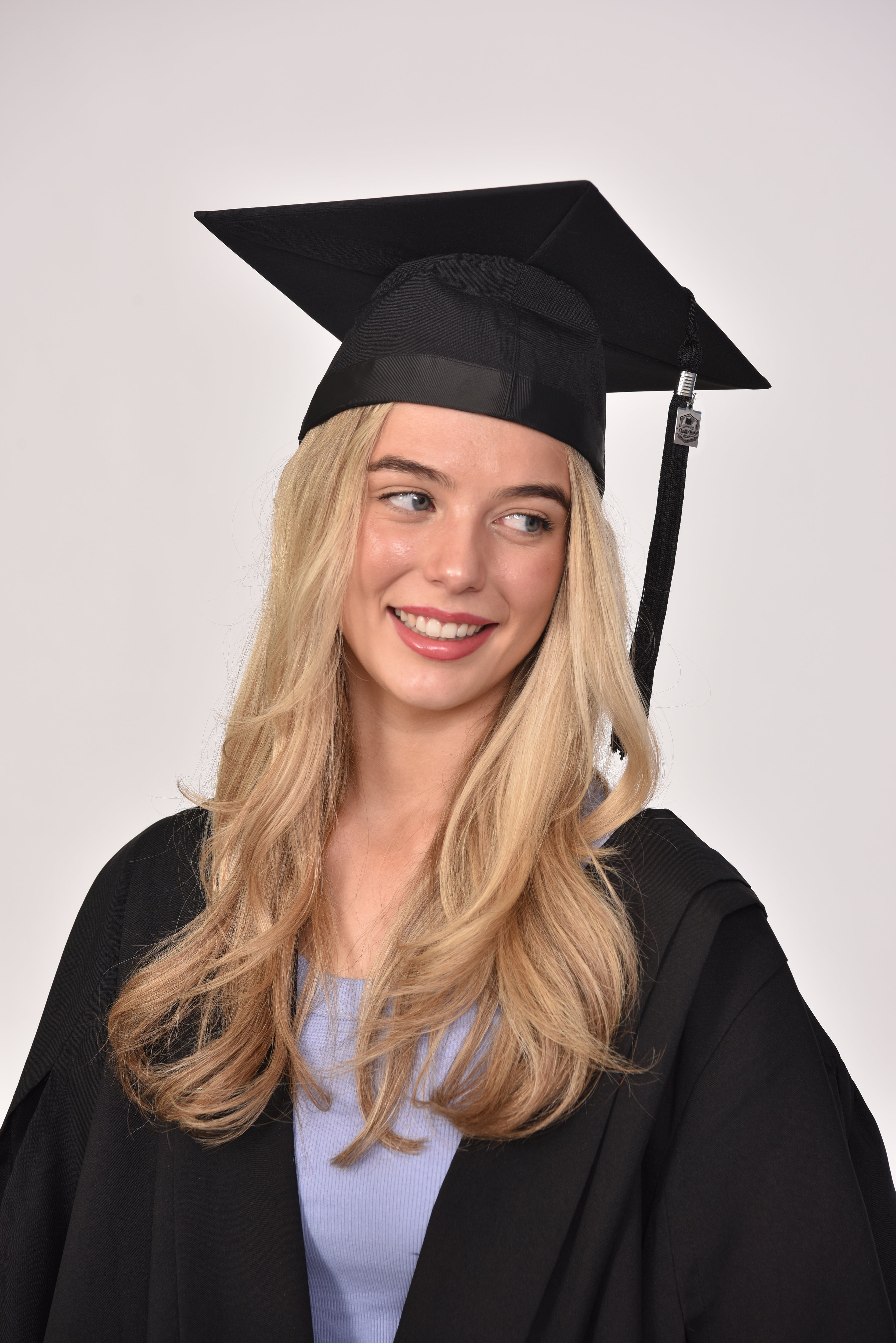 Model wearing black graduation cap with custom tassel charm
